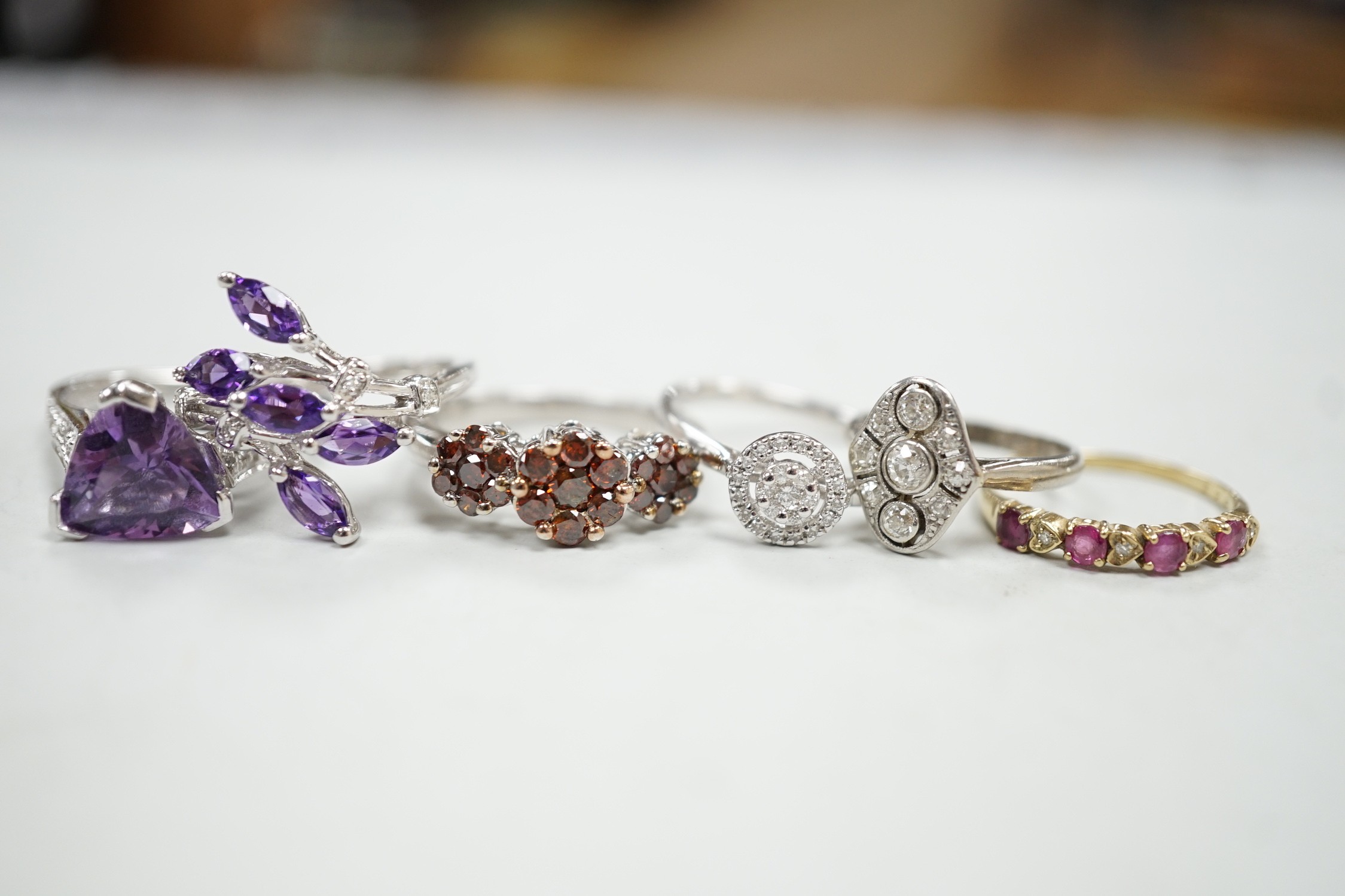 Five assorted modern 9ct gold and gem set dress rings, including diamond cluster ring, gross weight 14.2 grams, together with a 1920's style small white metal and millegrain set diamond cluster ring, size F/G, gross 2.6